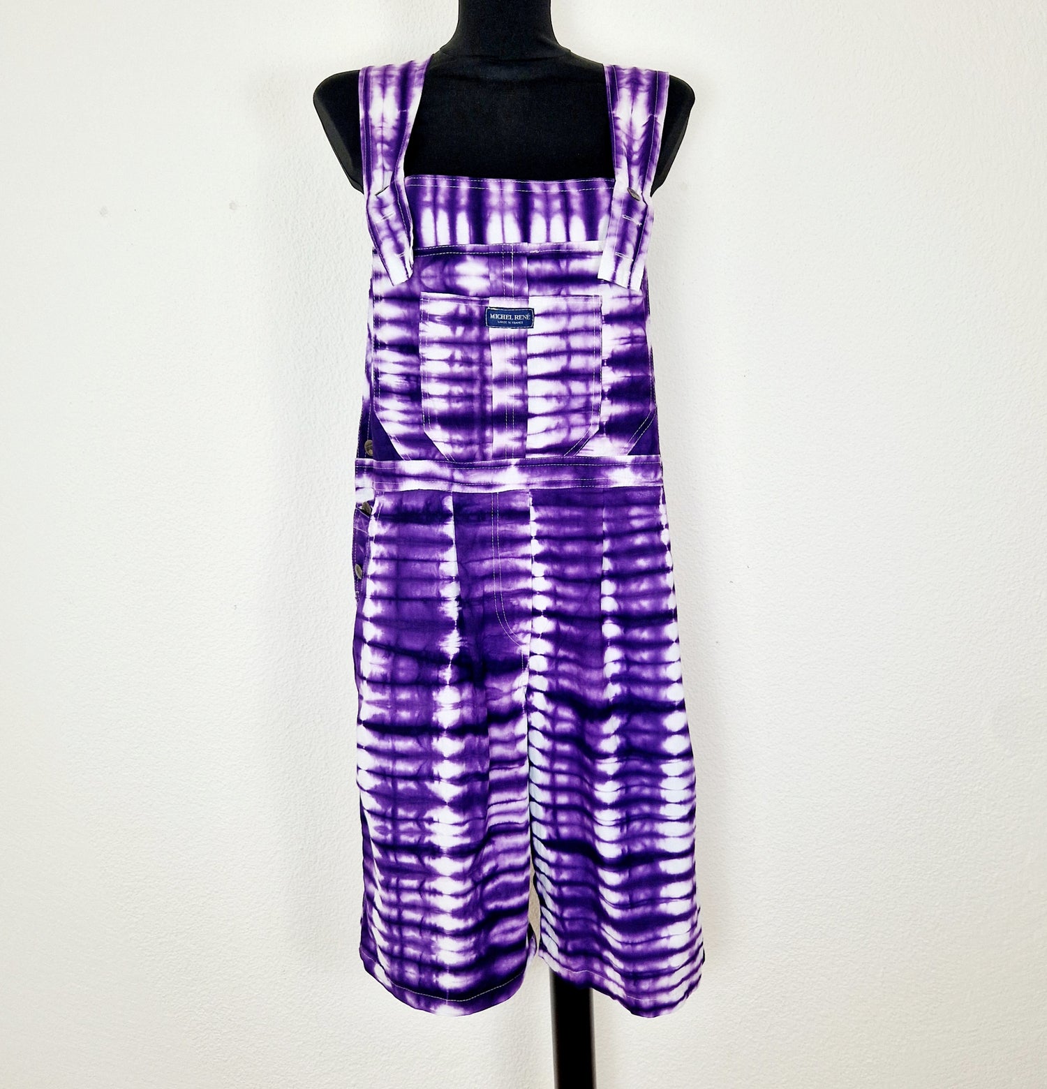 Einzigartige und nachhaltige Vintage Latzhose in violett-weiss mit Batik. Unique and sustainable vintage dungarees in purple-white with tie-dye. Front.