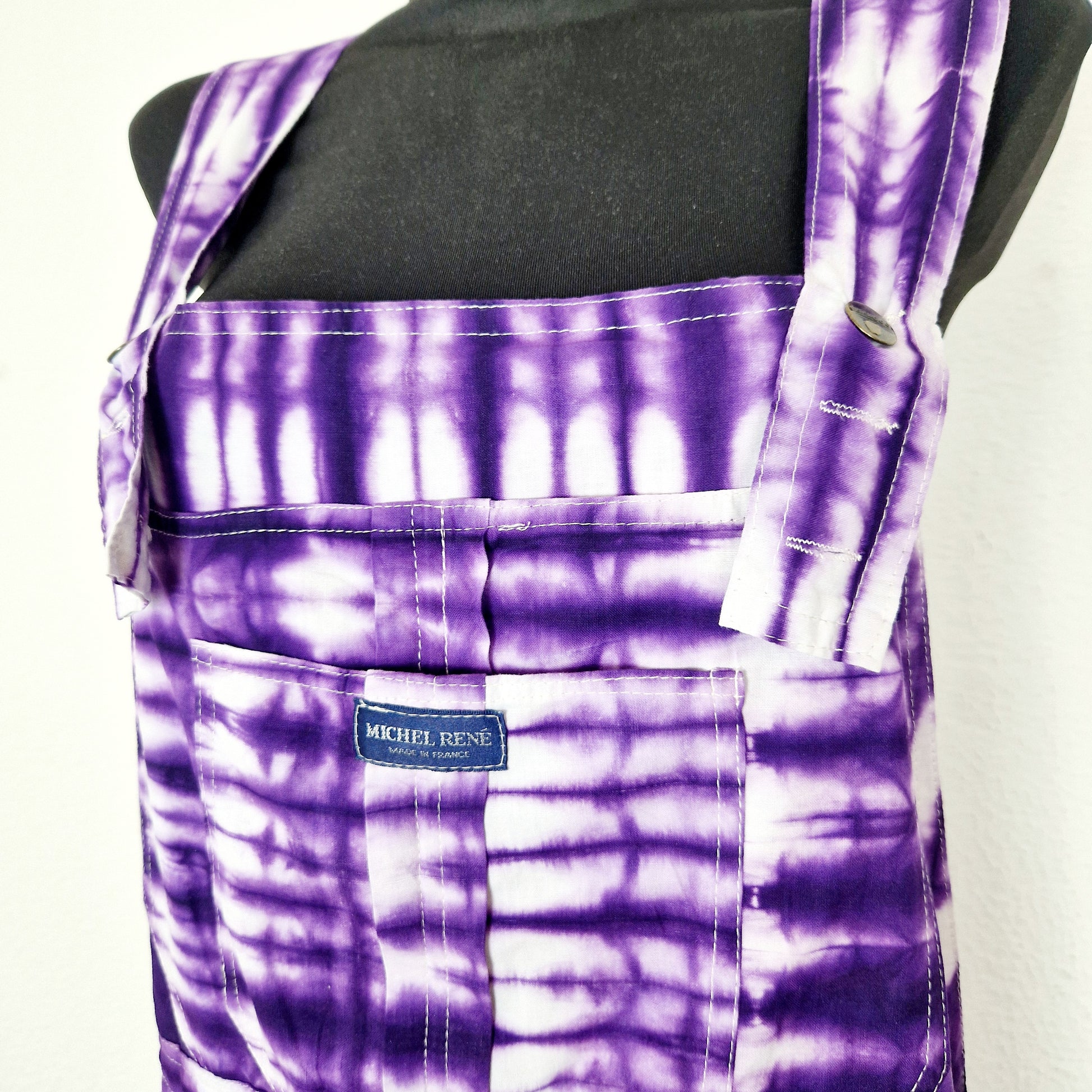 Einzigartige und nachhaltige Vintage Latzhose in violett-weiss mit Batik. Unique and sustainable vintage dungarees in purple-white with tie-dye. Close-up.