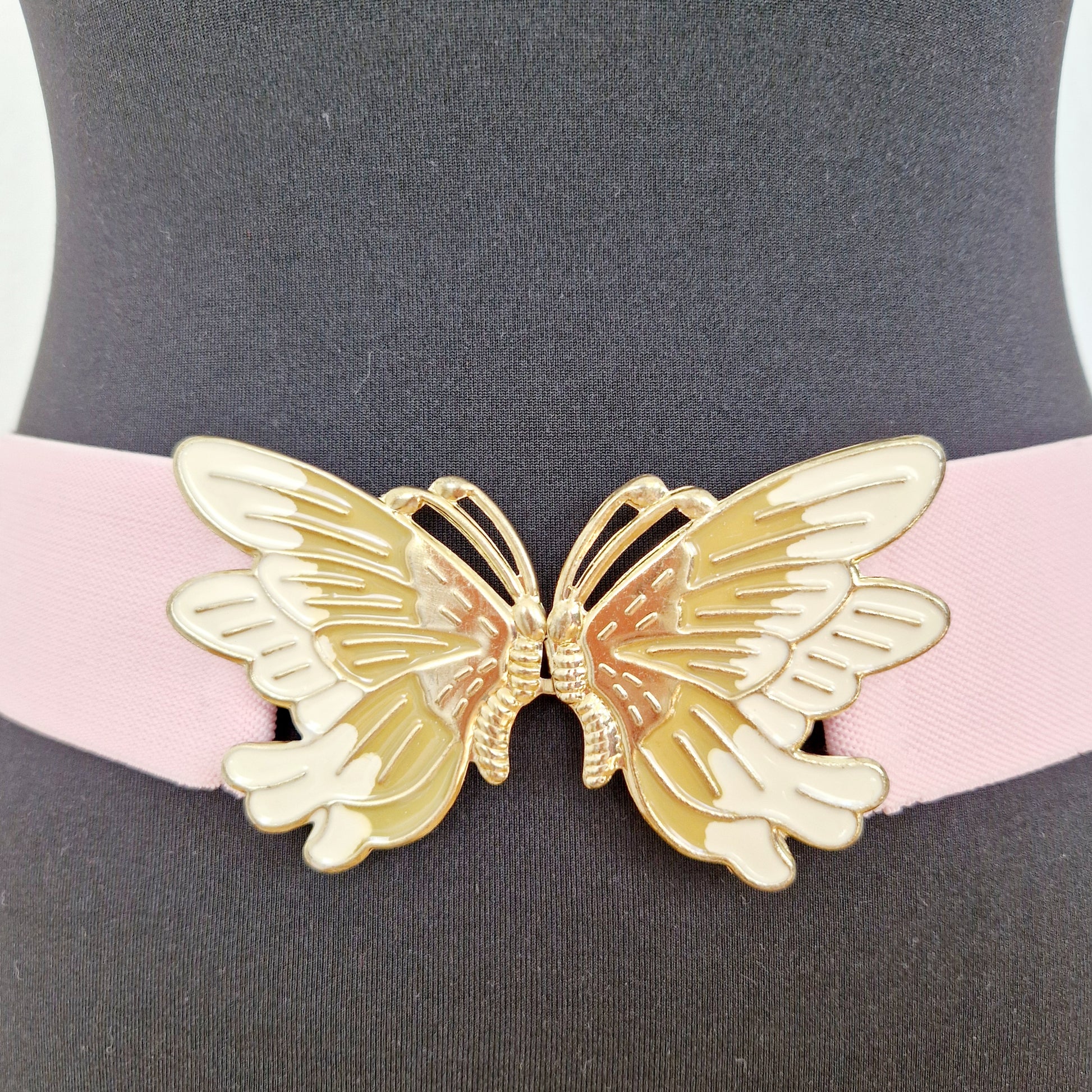 Einzigartiger und nachhaltiger Vintage Gürtel in rosa-gold mit Schmetterling. Unique and sustainable vintage belt in pink-gold with a butterfly. Close-up.