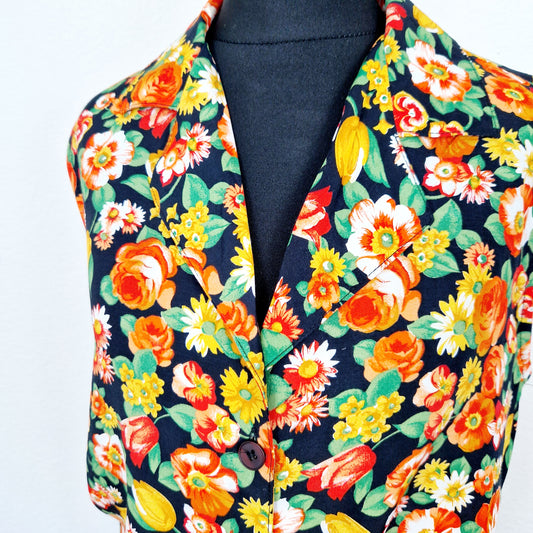 Einzigartiges und nachhaltiges Vintage Top in schwarz-orange-grün mit Blumen. Unique and sustainable vintage top in black-orange-green with flowers. Close-up.