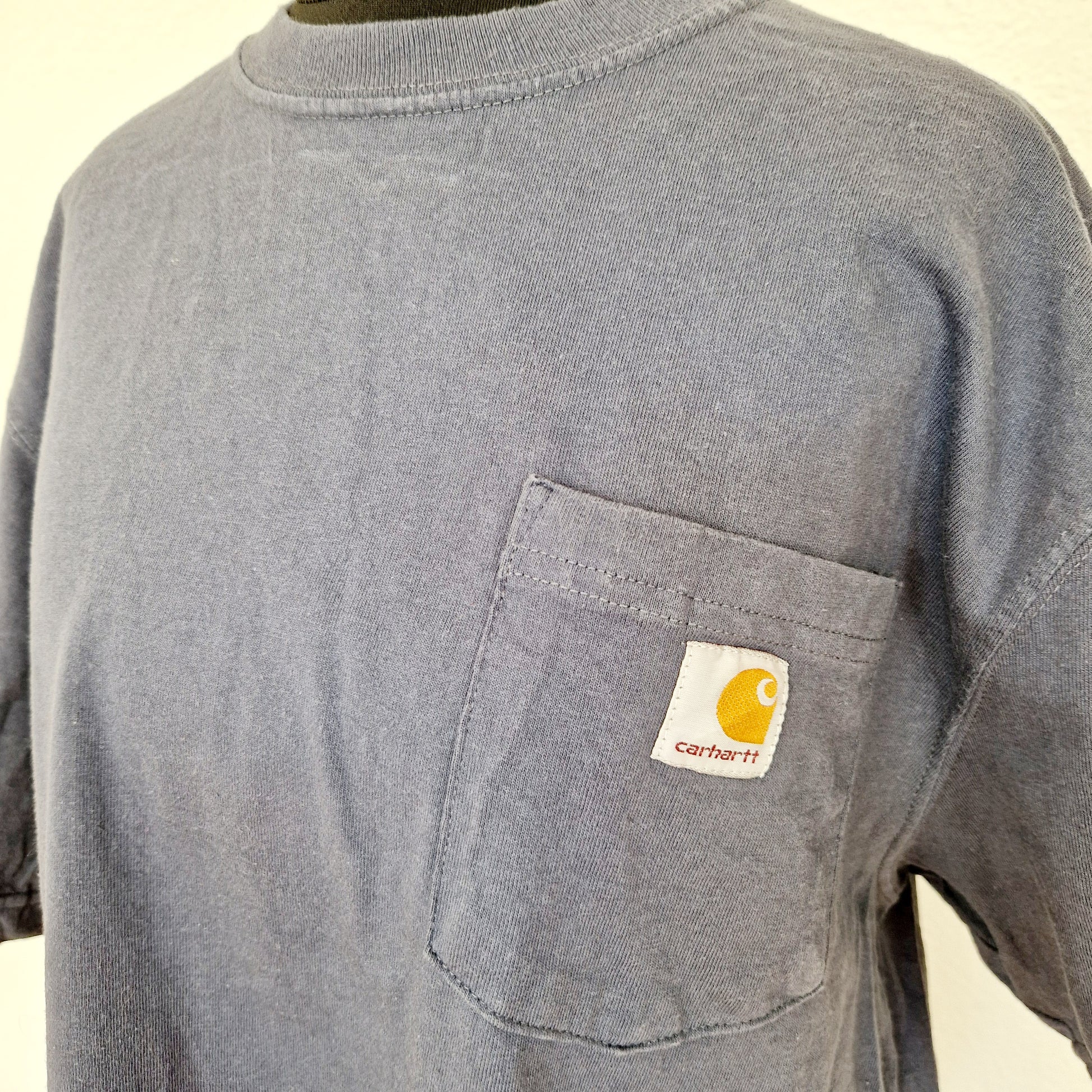 Einzigartiges und nachhaltiges Vintage T-Shirt in blaugrau von Carhartt. Unique and sustainable vintage t-shirt in blue grey from Carhartt. Close-up.