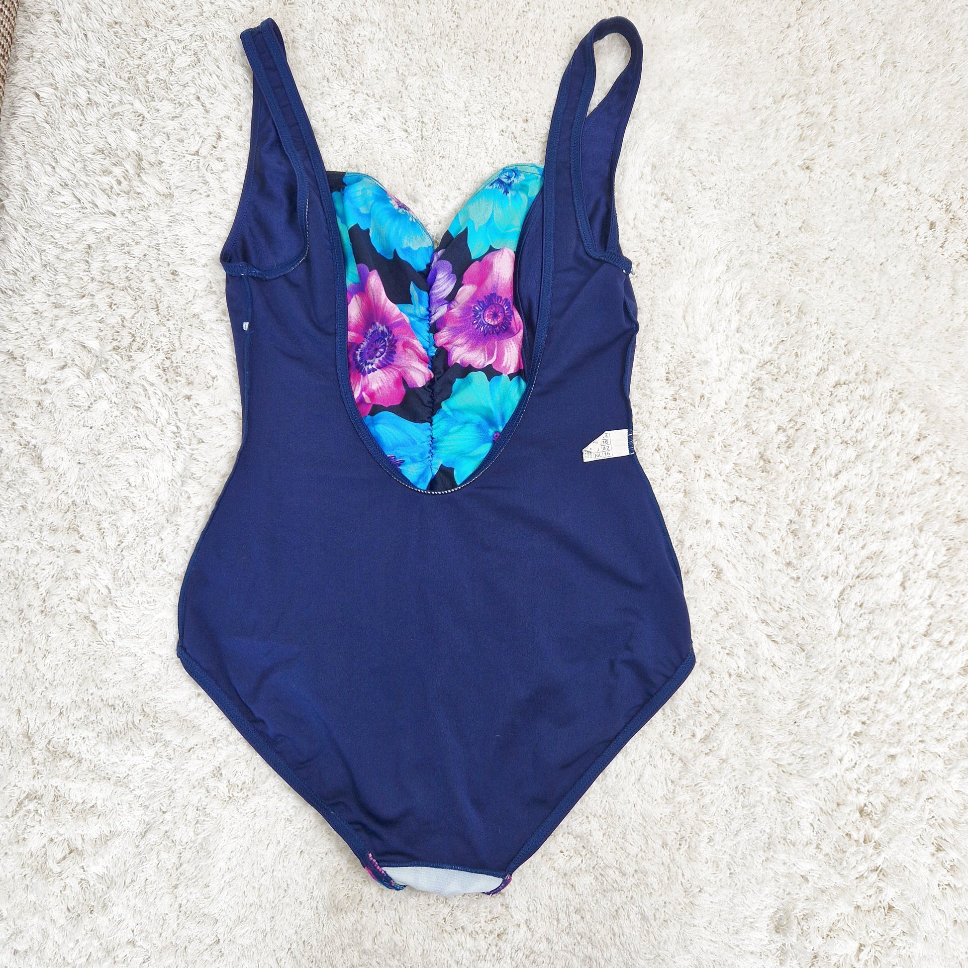 Einzigartiger und nachhaltiger Vintage Badeanzug in dunkelblau-violett-türkis mit Blumen. Unique and sustainable vintage swimsuit in darkblue-purple-turquois with flower. Back.