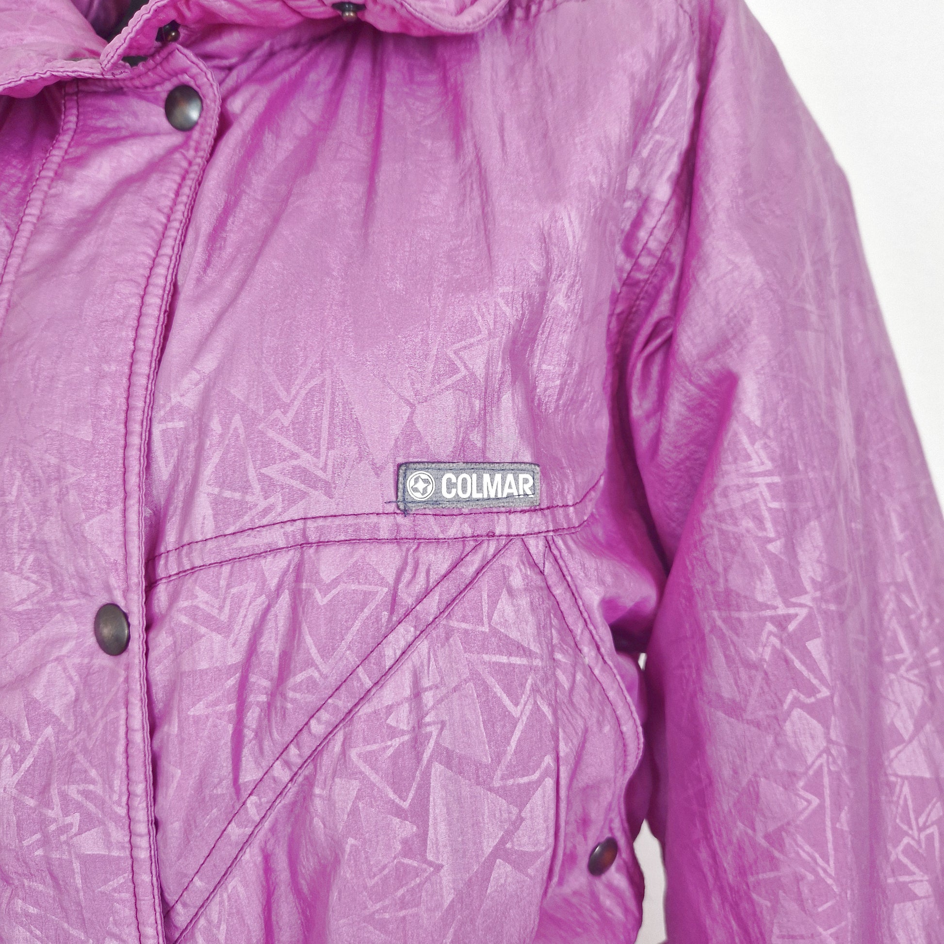 Einzigartiger und nachhaltiger Vintage Skianzug in lila. Unique and sustainable vintage ski suit in purple. Close-up.