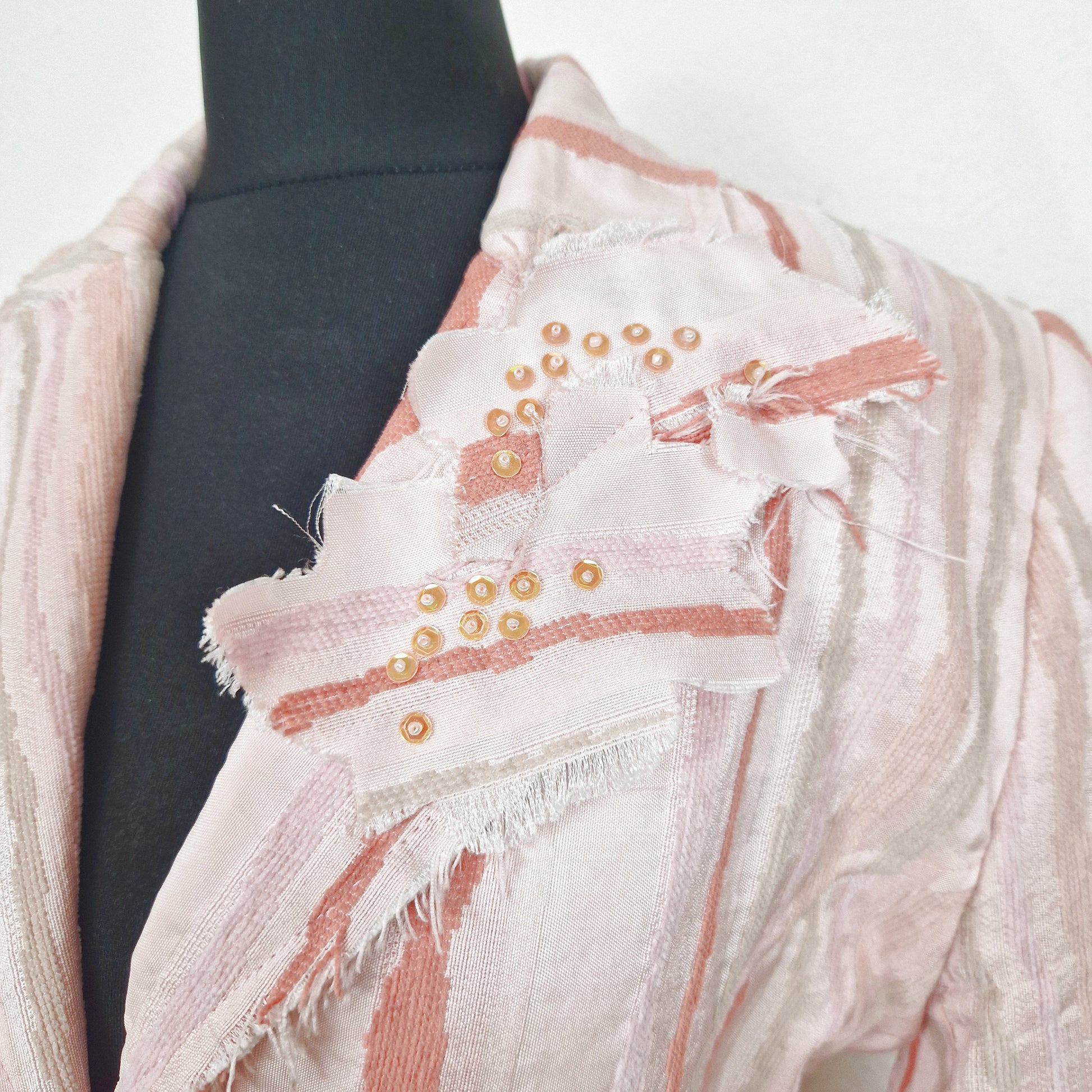 Einzigartiger und nachhaltiger Vintage Blazer in rosa-lachs-beige mit Streifen. Unique and sustainable vintage blazer in pink-salmon-beige with stripes. Close-up.