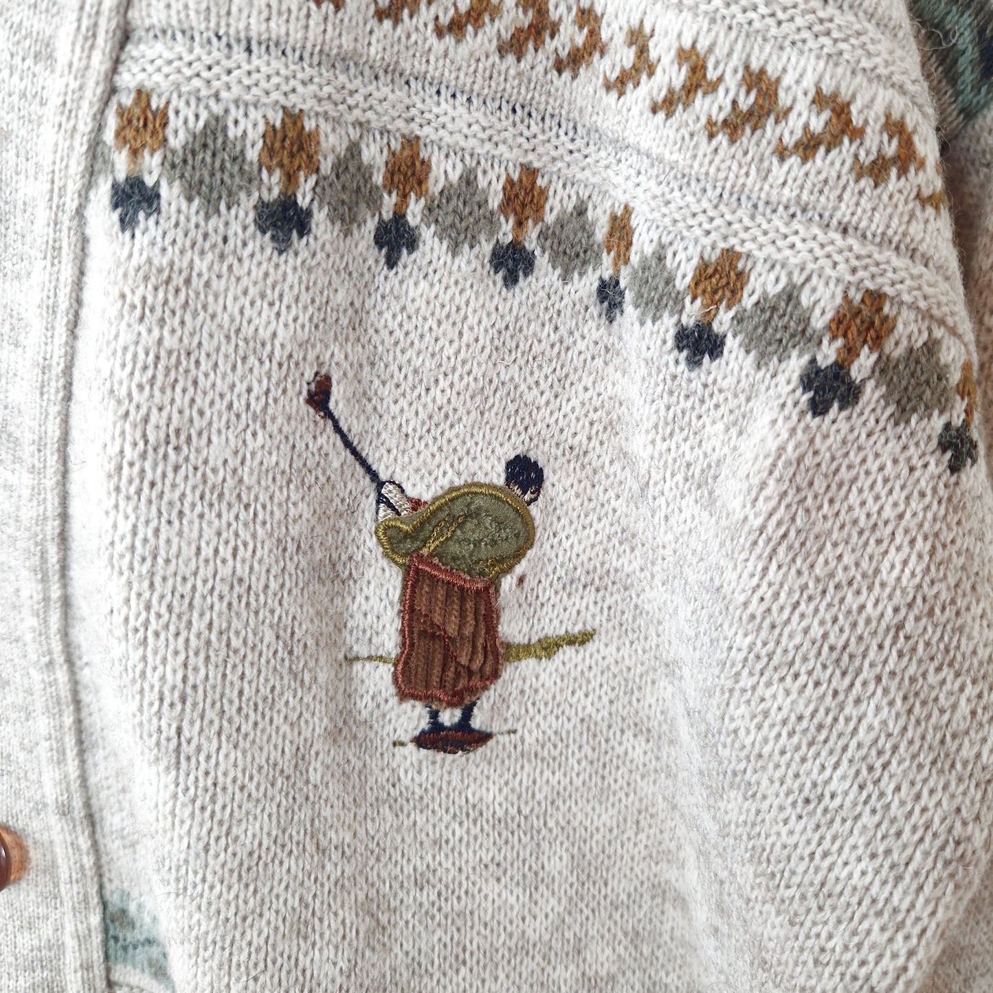 Einzigartiger und nachhaltiger Vintage Cardigan in sand-hellgrau-khaki mit geometrischem Muster und Golfer. Close-up 2.