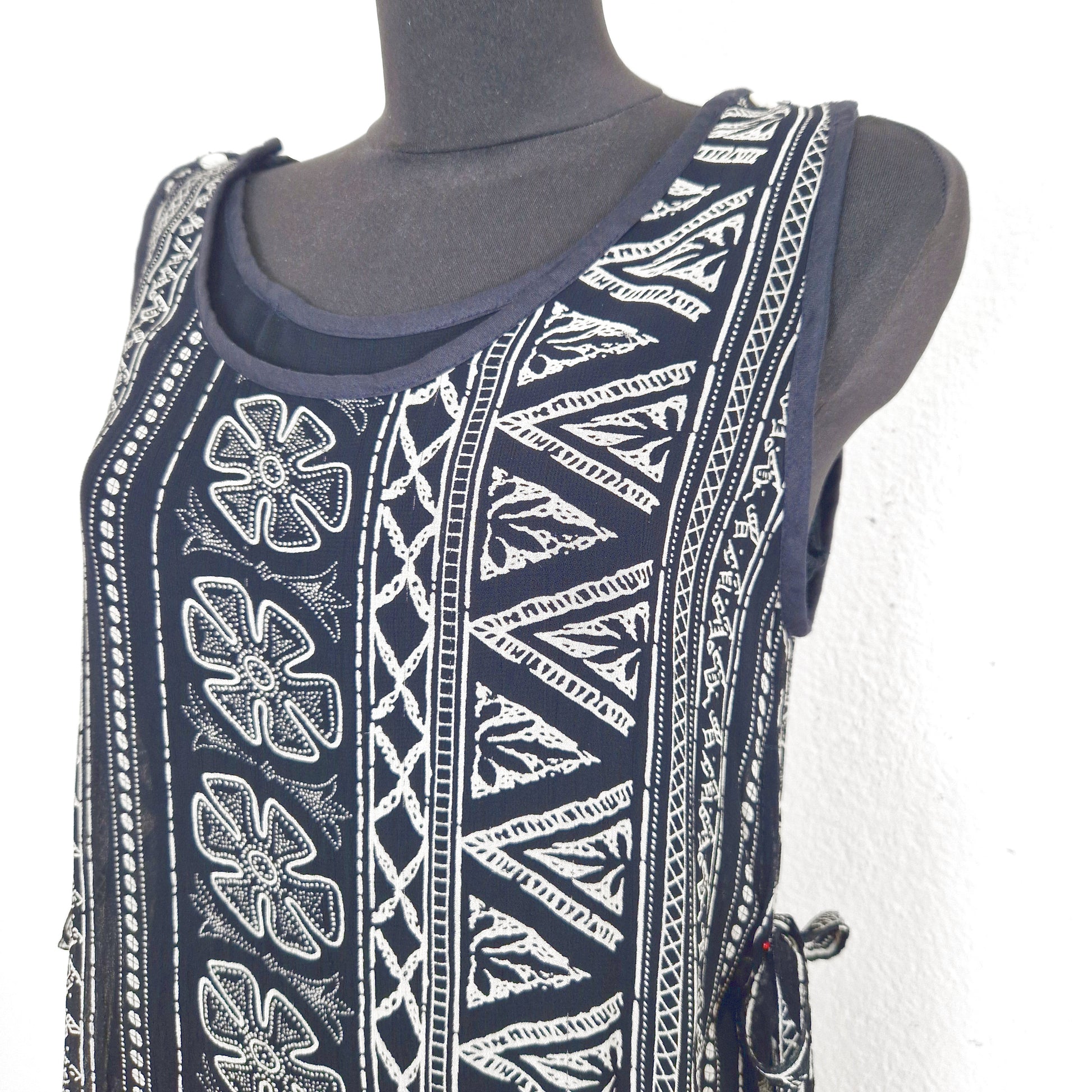 Einzigartiger und nachhaltiger Vintage Playsuit in schwarz-elfenbein mit Schichtenoptik und Ethno-Muster.  Close-up.