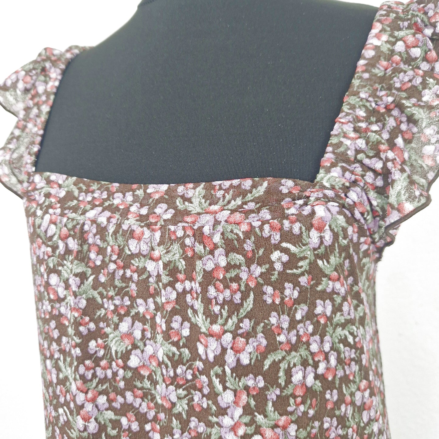 Einzigartiges und nachhaltiges Vintage Trägerkleid in braun-lila-rot mit Blumen und Rüschenärmeln. Close-up.
