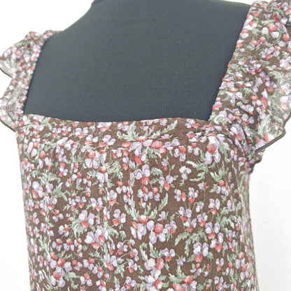 Einzigartiges und nachhaltiges Vintage Trägerkleid in braun-lila-rot mit Blumen und Rüschenärmeln. Close-up.