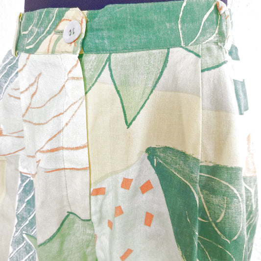 Einzigartige und nachhaltige Vintage Shorts in hellgrün-gelb-orange mit Blättern. Close-up.