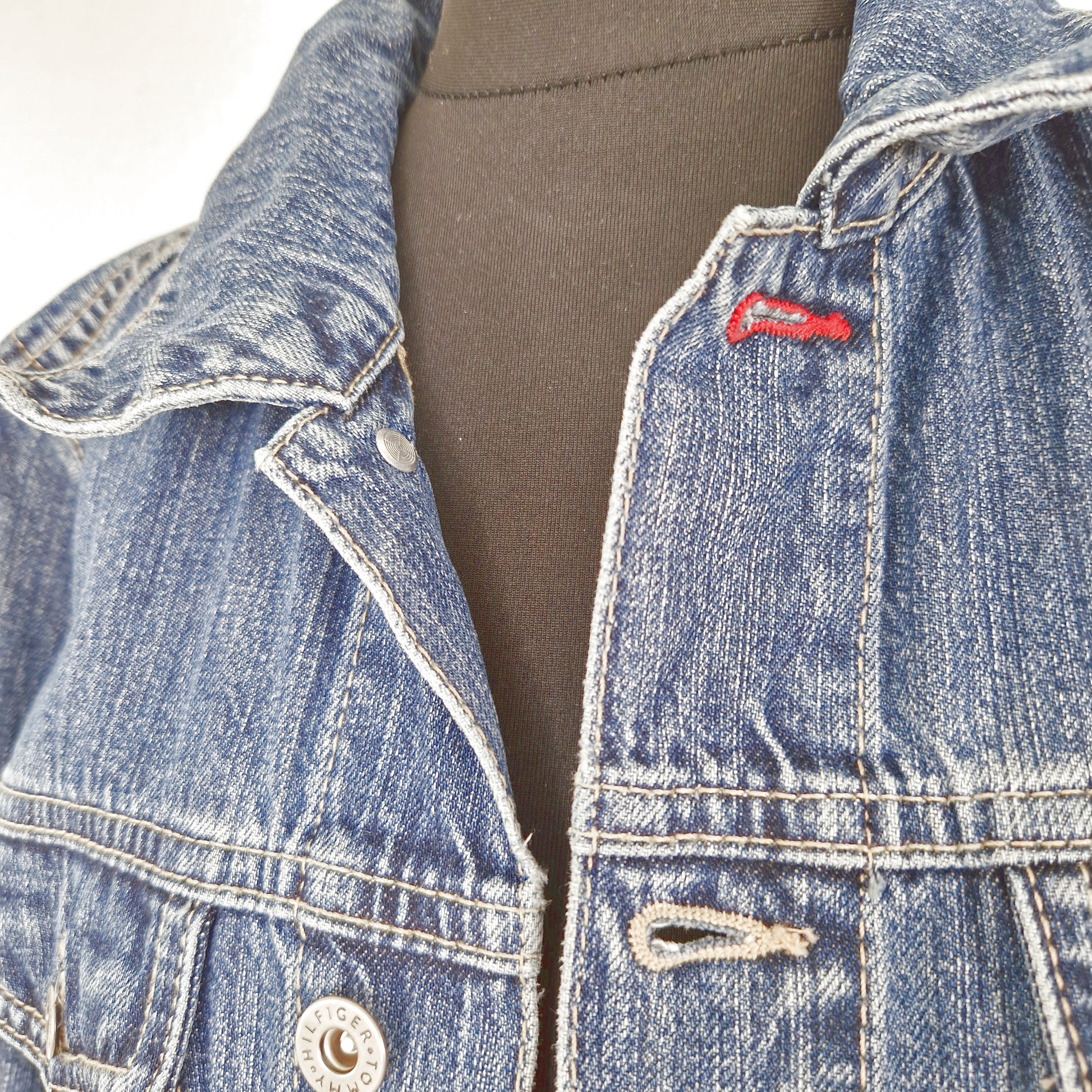 Einzigartige und nachhaltige Vintage Jeansjacke in blau von Tommy Hilfiger. Close-up.