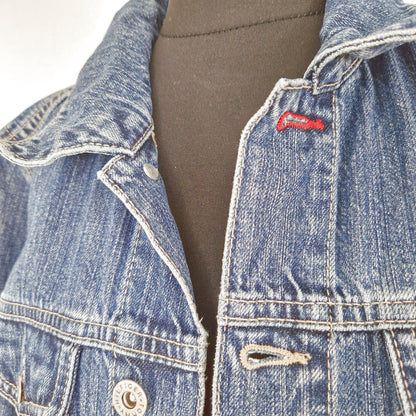Einzigartige und nachhaltige Vintage Jeansjacke in blau von Tommy Hilfiger. Close-up.