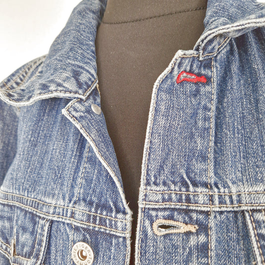 Einzigartige und nachhaltige Vintage Jeansjacke in blau von Tommy Hilfiger. Close-up.