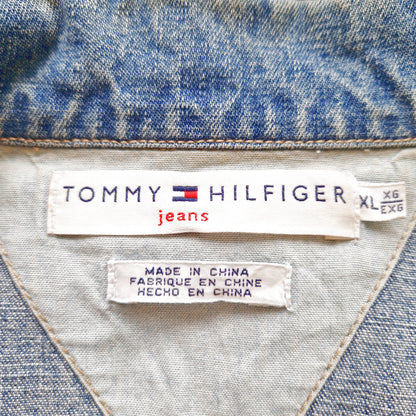 Einzigartige und nachhaltige Vintage Jeansjacke in blau von Tommy Hilfiger mit USA Fahne. Tag.