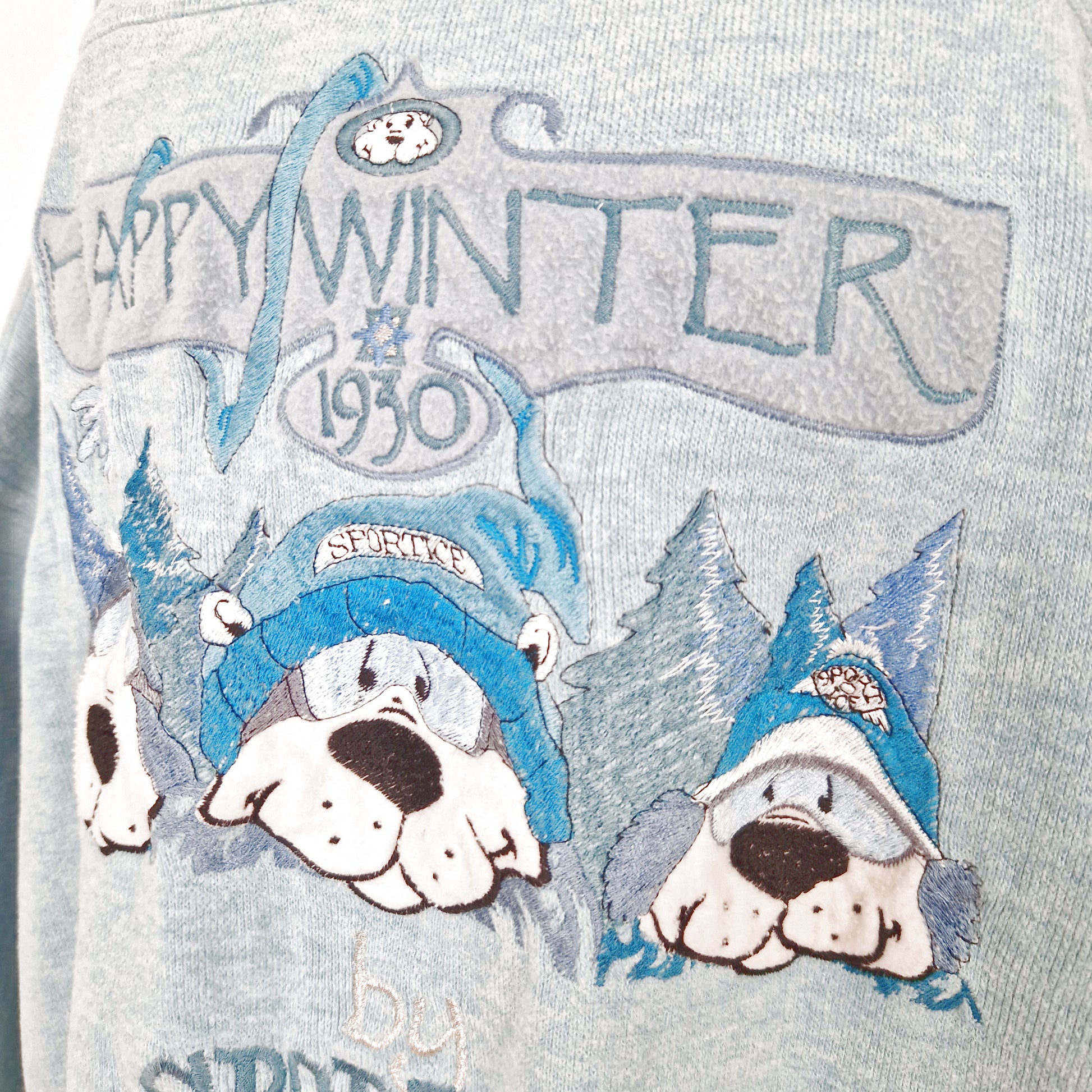 Einzigartiger und nachhaltiger Vintage Pullover in hellblau-türkis-silber mit drei Hunden. Close-up.