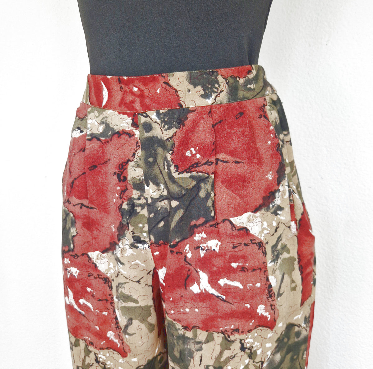 Einzigartige und nachhaltige Vintage Hose in braun-grün-khaki mit Blattmuster. Close-up.