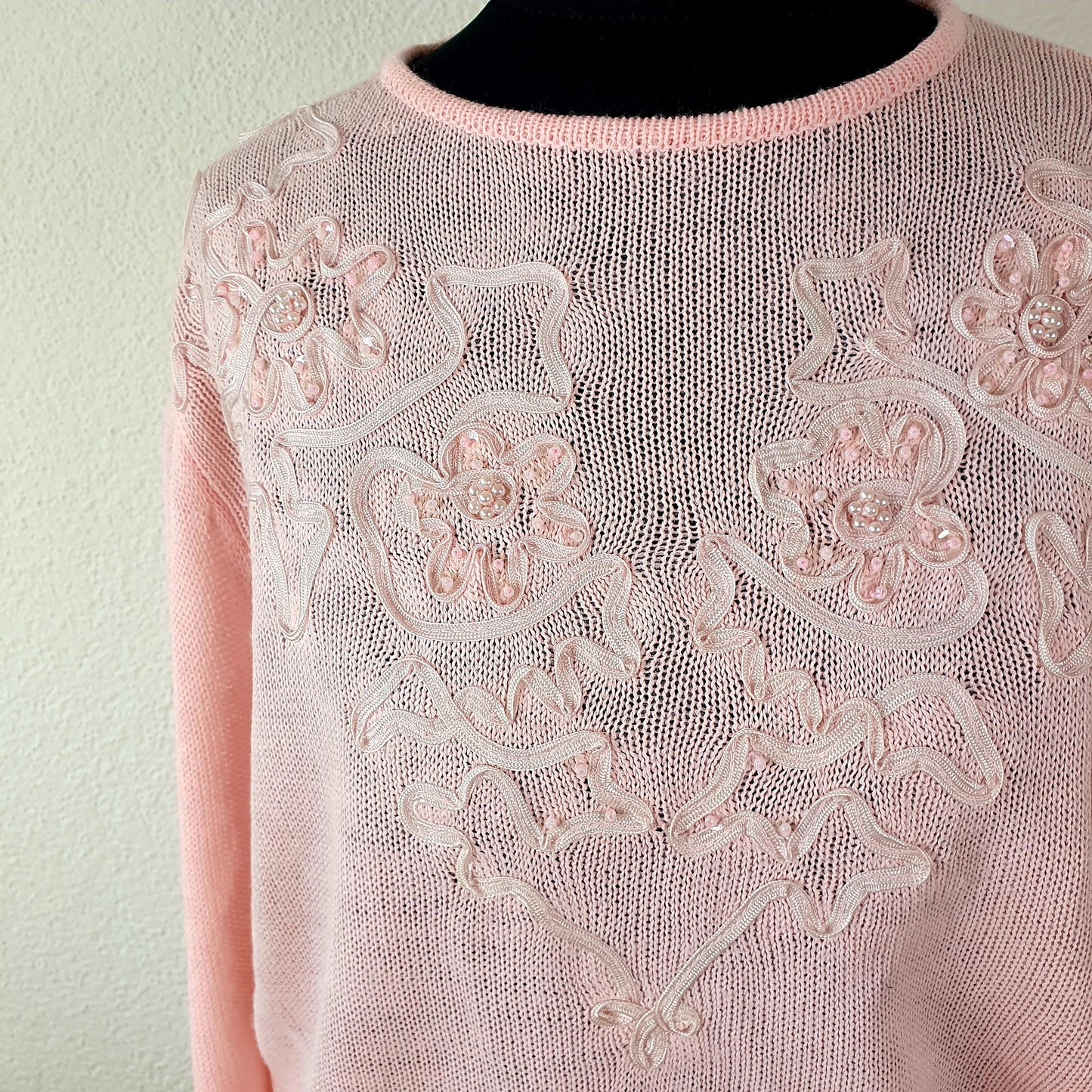 Einzigartiger und nachhaltiger Vintage Pullover in pink mit Blumen. Unique and sustainable vintage pullover in pink with flowers. Close-up.