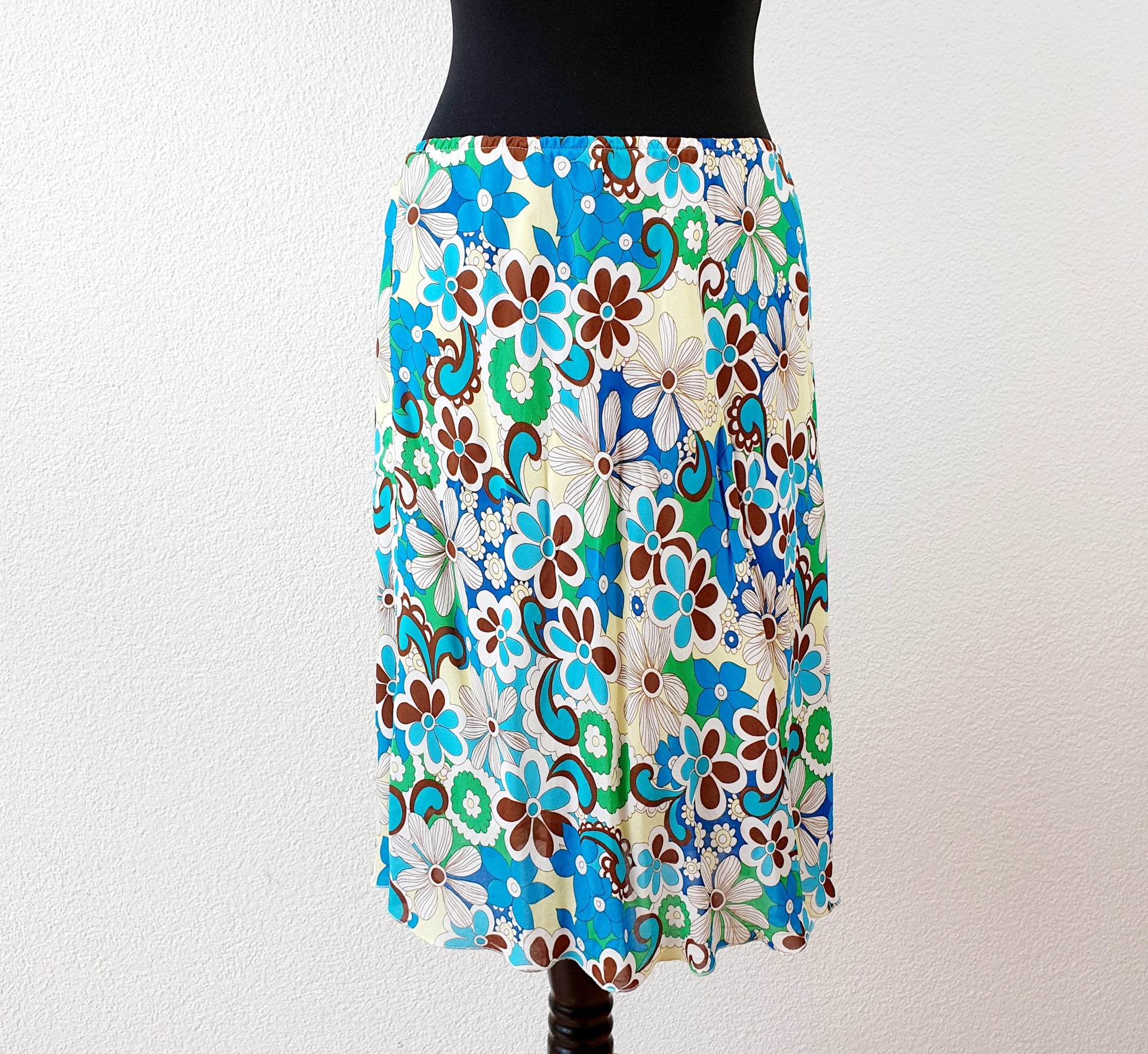 Einzigartiger und nachhaltiger Vintage Rock in türkis-grün-gelb mit Blumen. Unique and sustainable vintage skirt in turquoise-green-yellow with flowers. Front.