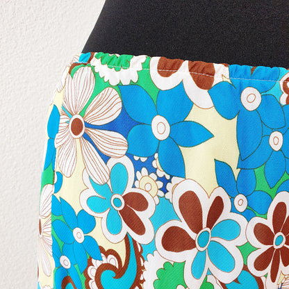 Einzigartiger und nachhaltiger Vintage Rock in türkis-grün-gelb mit Blumen. Unique and sustainable vintage skirt in turquoise-green-yellow with flowers. Close-up.