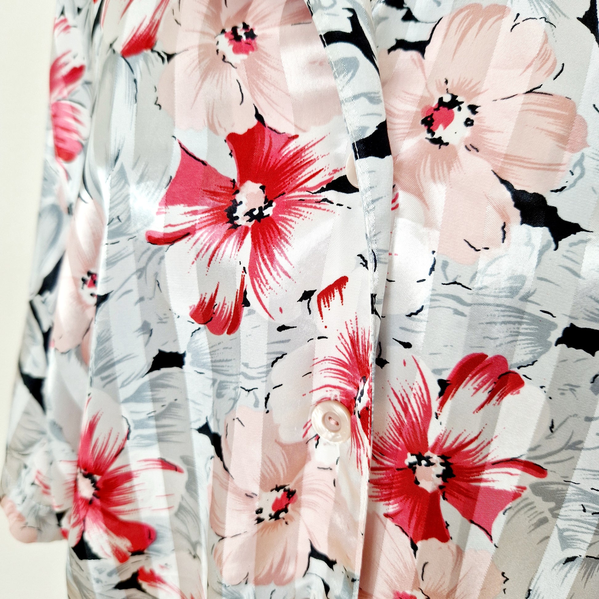 Einzigartige und nachhaltige Vintage Bluse in weiss-rot-rosa mit Blumen. Unique and sustainable vintage blouse in white-red-pink with flowers. Close-up.